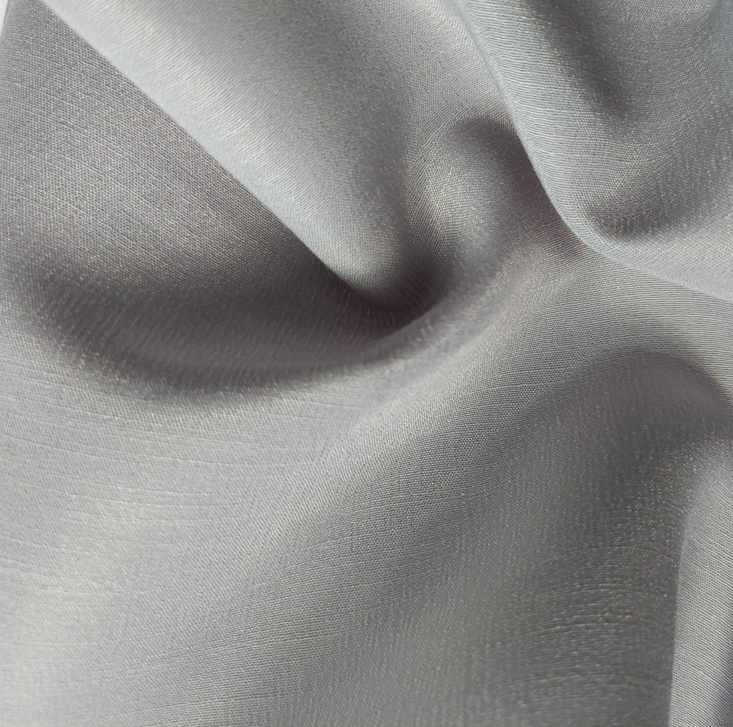 Close-up of soft, wrinkled pink cotton fabric displaying fine weave texture.