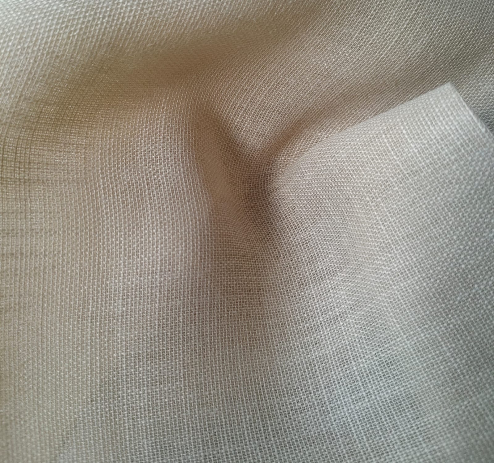 Close-up of soft, wrinkled pink cotton fabric displaying fine weave texture.