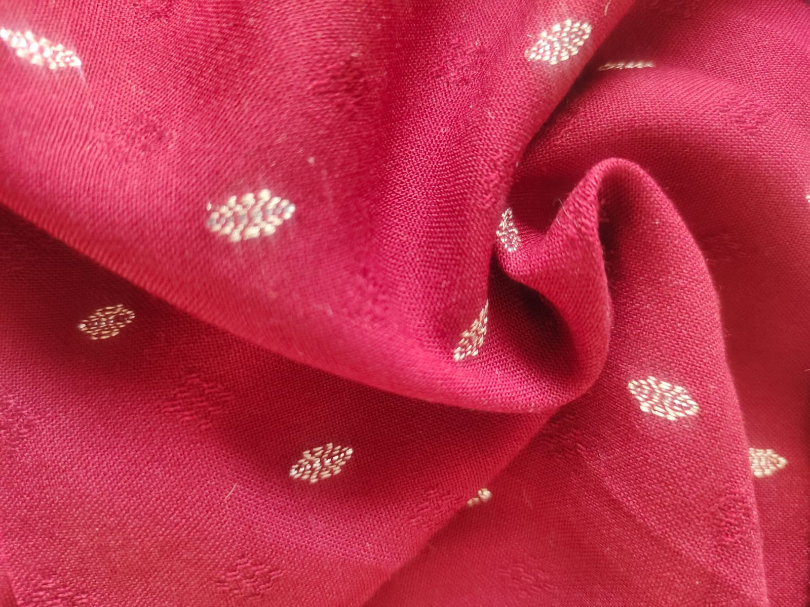 Close-up of soft, wrinkled pink cotton fabric displaying fine weave texture.
