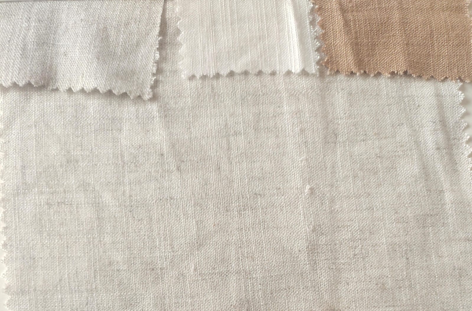 Close-up of soft, wrinkled pink cotton fabric displaying fine weave texture.