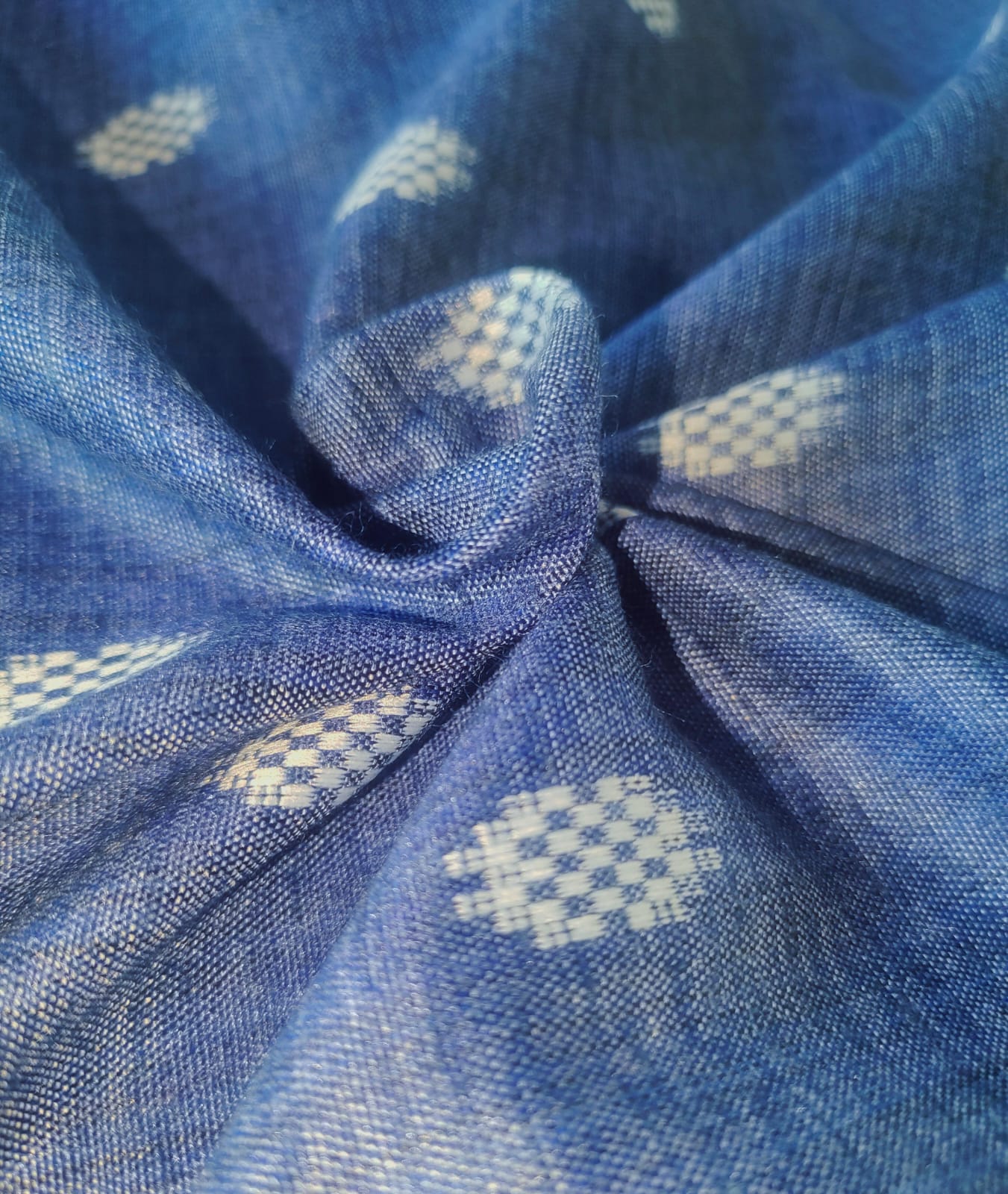 Close-up of soft, wrinkled pink cotton fabric displaying fine weave texture.