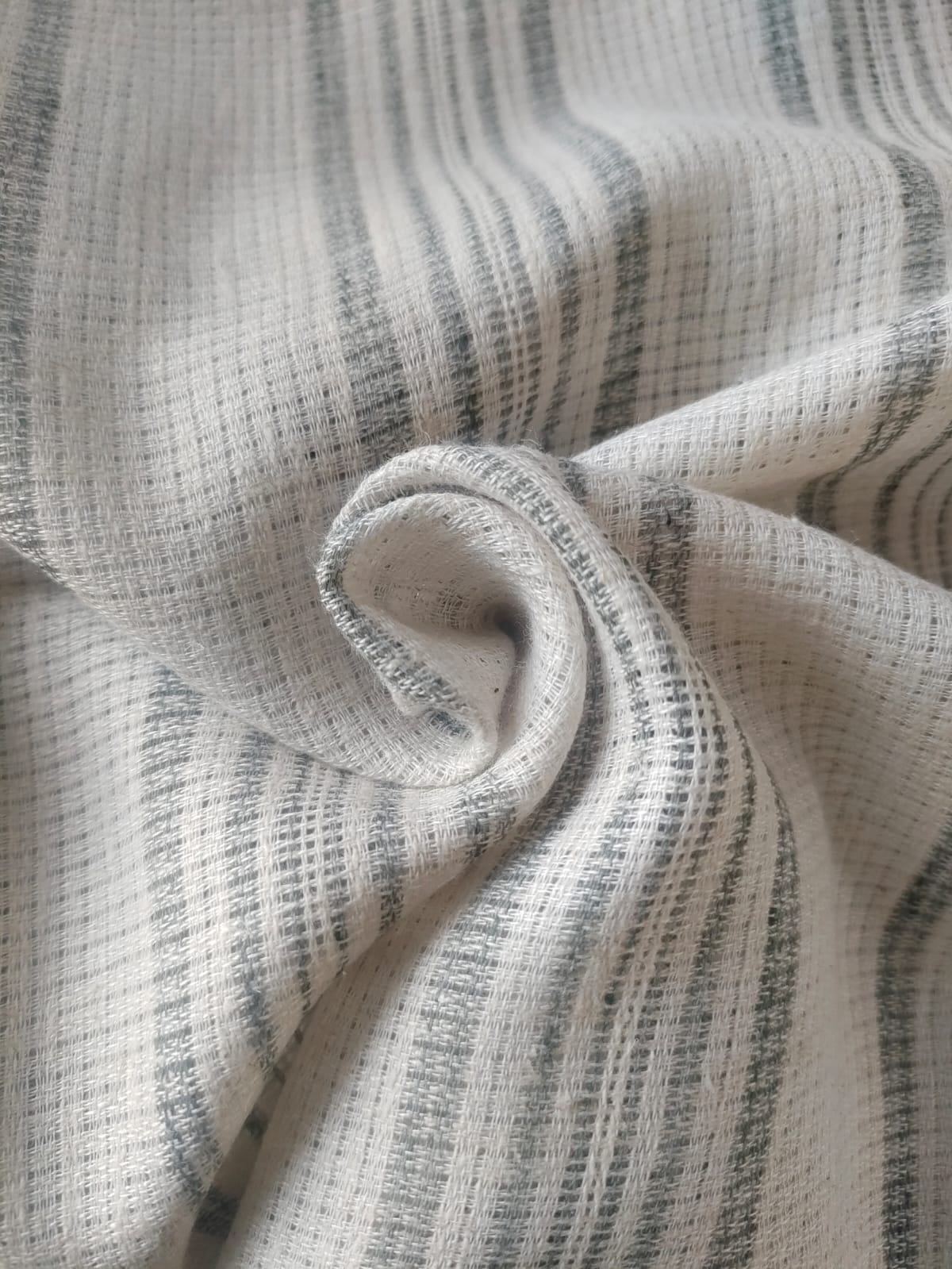 Close-up of soft, wrinkled pink cotton fabric displaying fine weave texture.