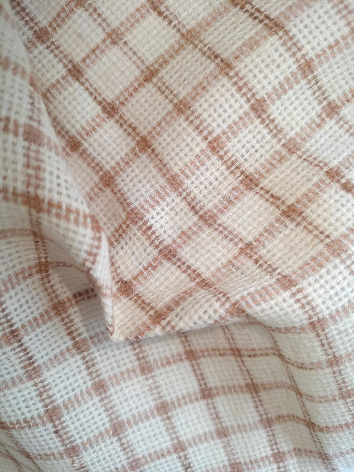 Close-up of soft, wrinkled pink cotton fabric displaying fine weave texture.
