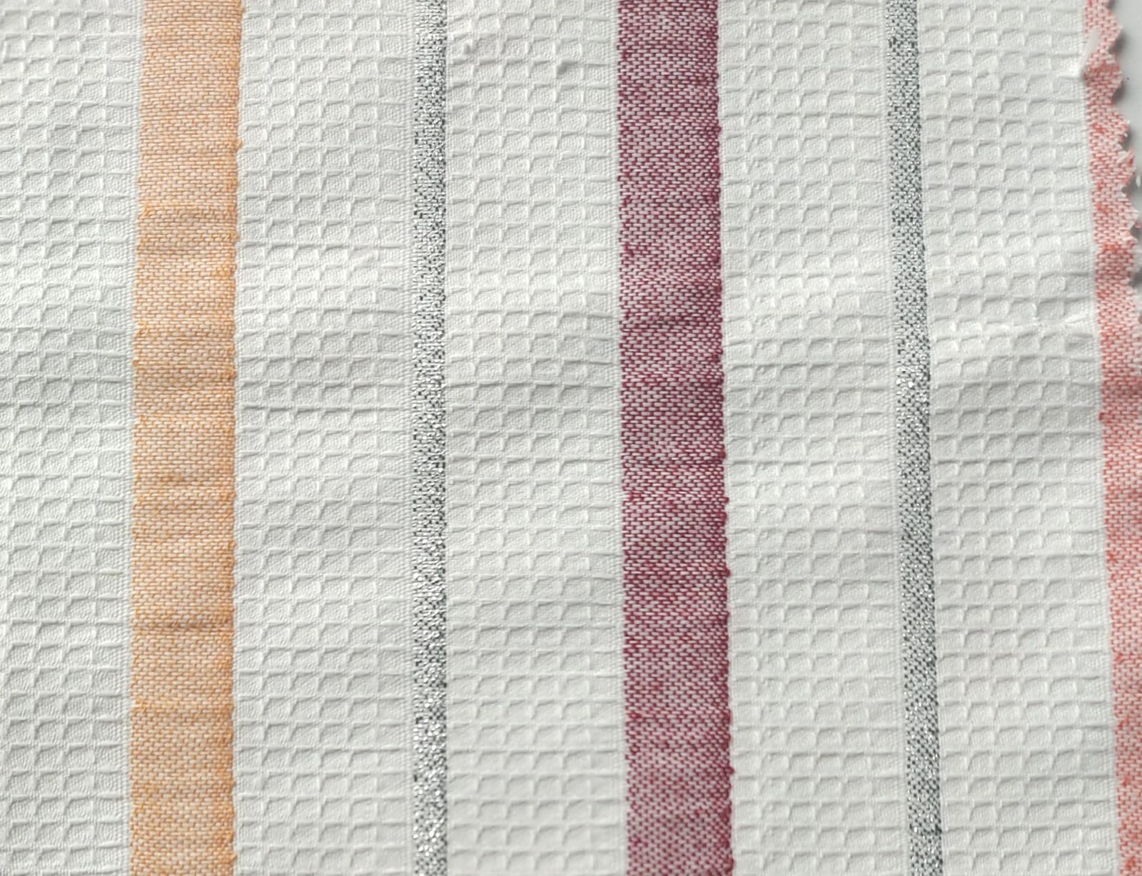 Close-up of soft, wrinkled pink cotton fabric displaying fine weave texture.