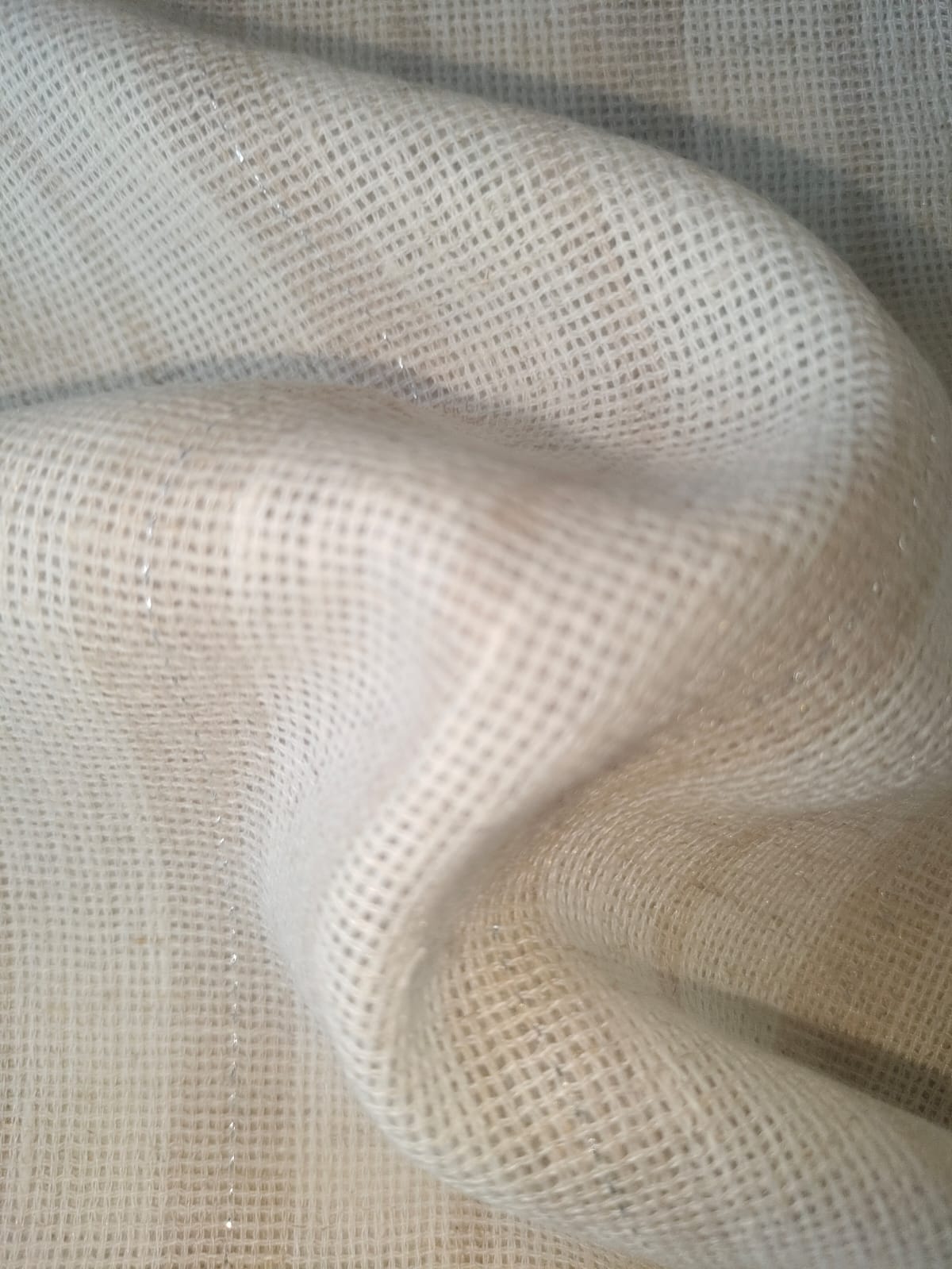 Close-up of soft, wrinkled pink cotton fabric displaying fine weave texture.
