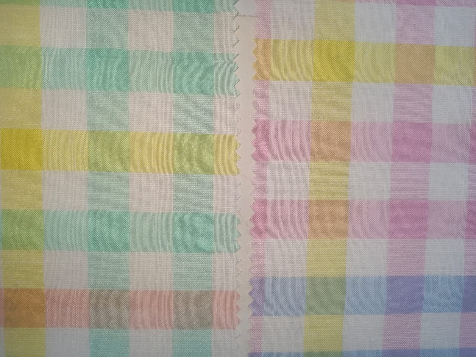Close-up of soft, wrinkled pink cotton fabric displaying fine weave texture.