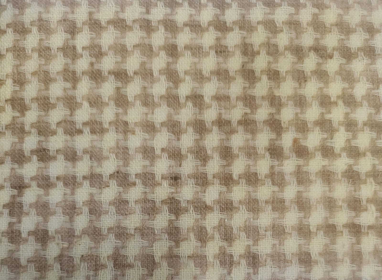 Close-up of soft, wrinkled pink cotton fabric displaying fine weave texture.