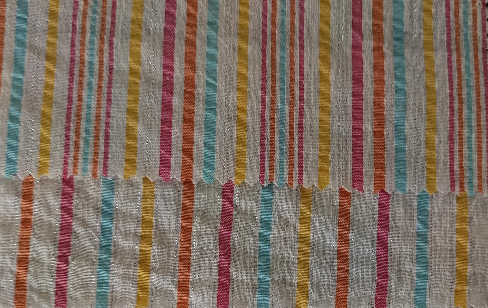 Close-up of soft, wrinkled pink cotton fabric displaying fine weave texture.