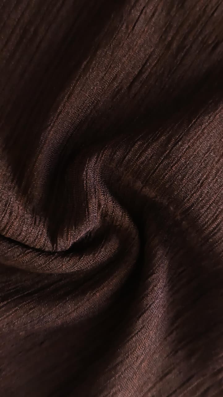 Close-up of soft, wrinkled pink cotton fabric displaying fine weave texture.