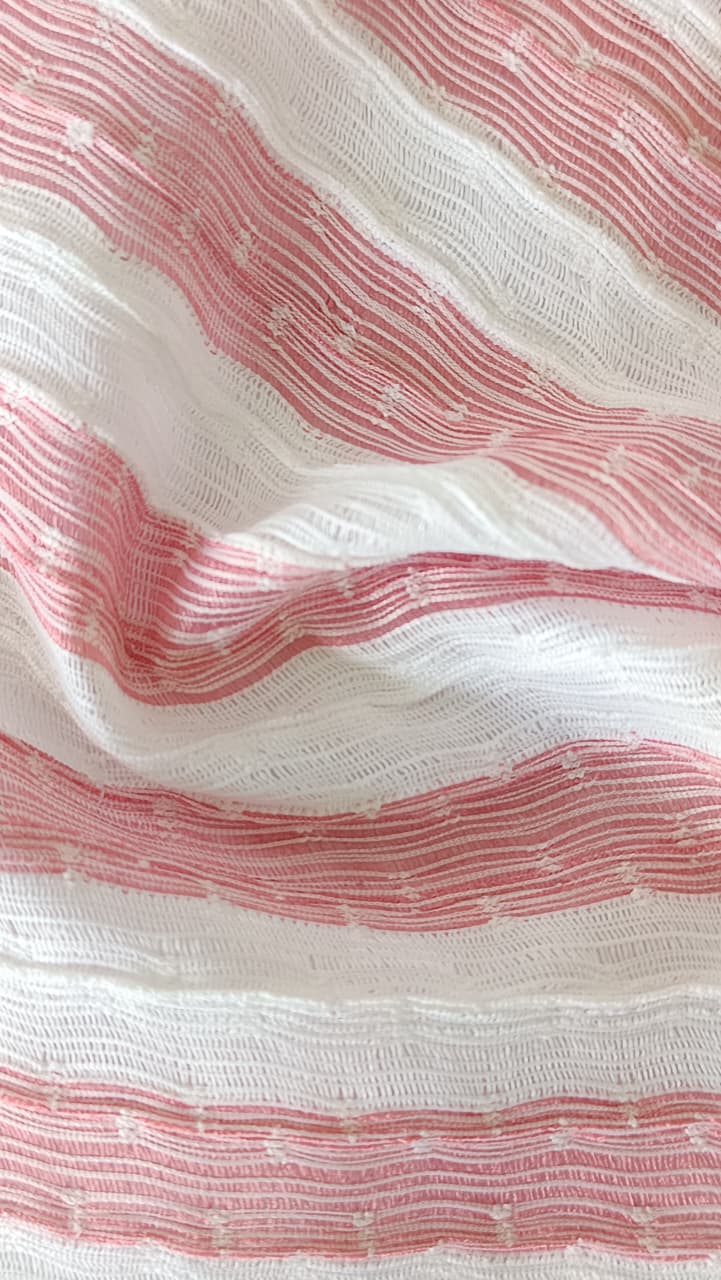 Close-up of soft, wrinkled pink cotton fabric displaying fine weave texture.