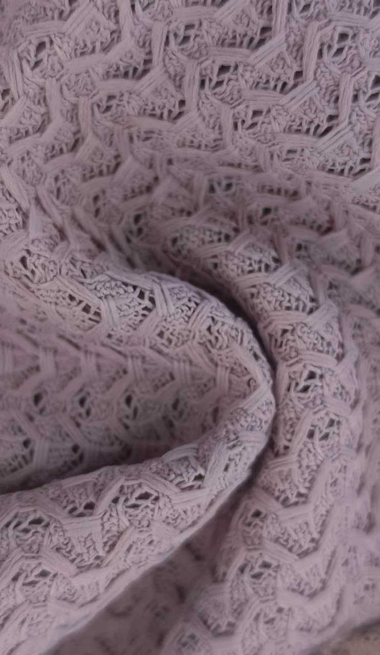 Close-up of soft, wrinkled pink cotton fabric displaying fine weave texture.