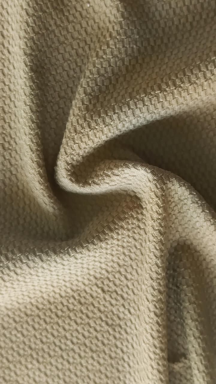 Close-up of soft, wrinkled pink cotton fabric displaying fine weave texture.
