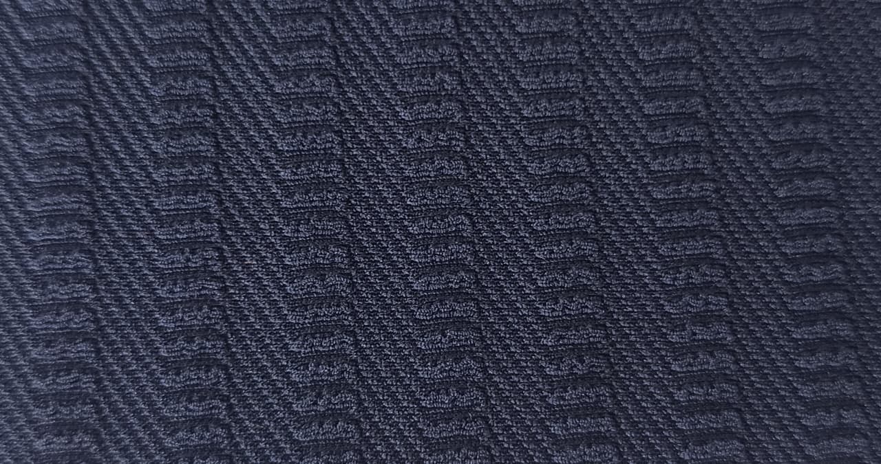 Close-up of soft, wrinkled pink cotton fabric displaying fine weave texture.