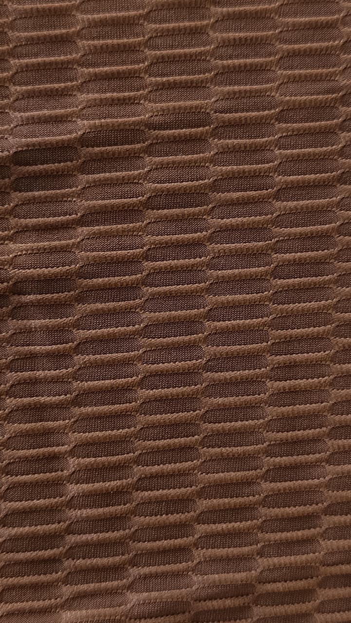Close-up of soft, wrinkled pink cotton fabric displaying fine weave texture.
