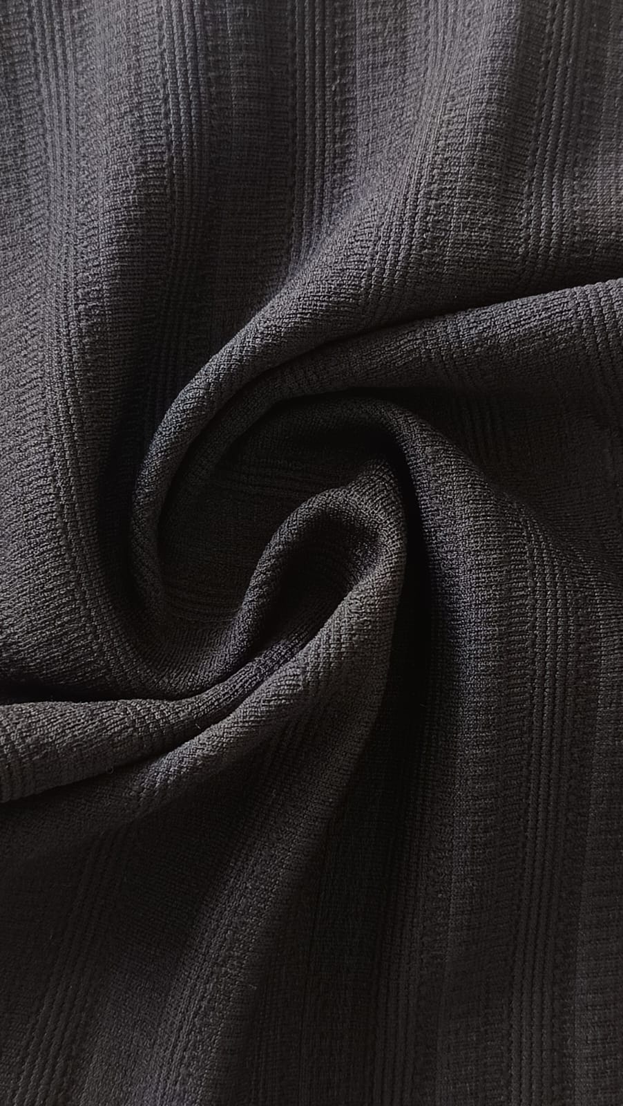 Close-up of soft, wrinkled pink cotton fabric displaying fine weave texture.