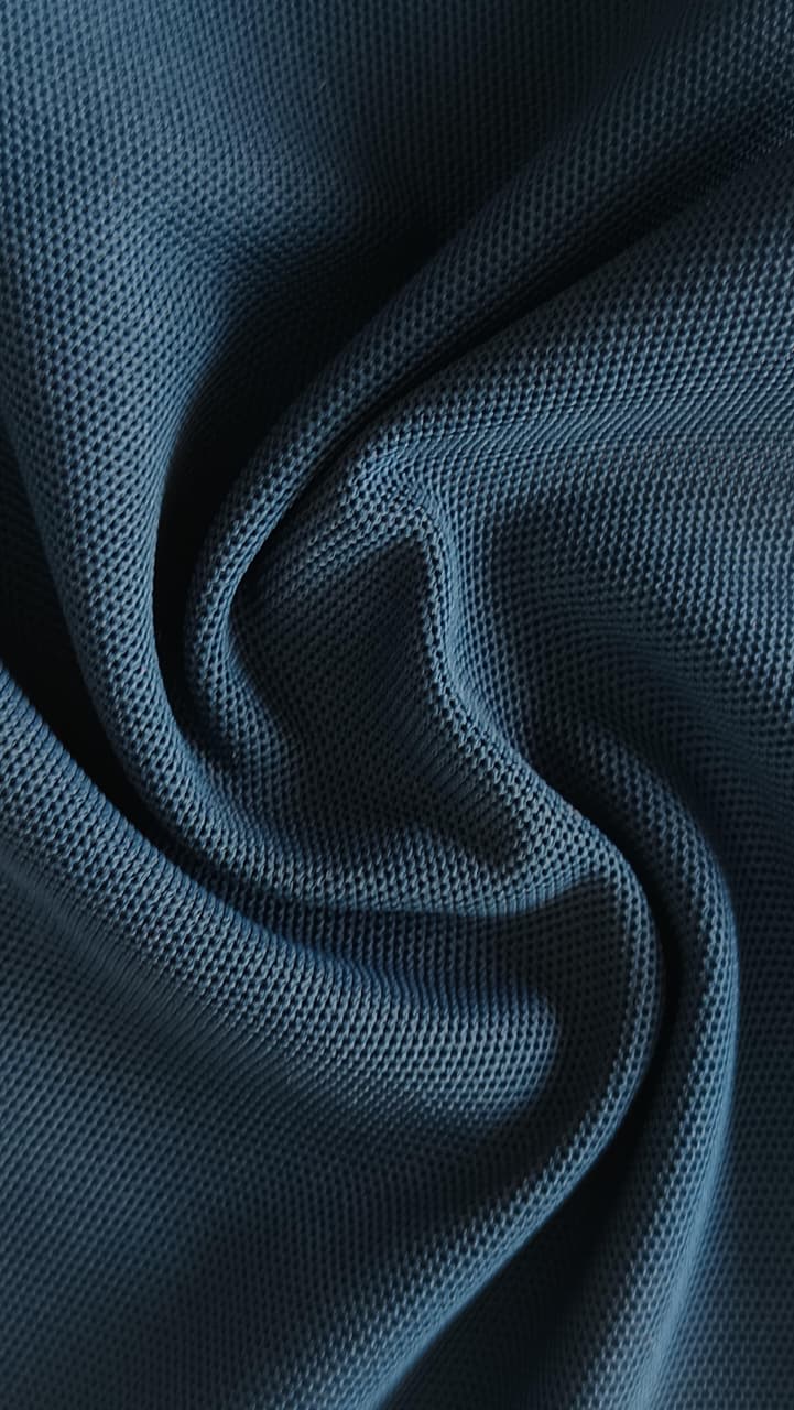 Close-up of soft, wrinkled pink cotton fabric displaying fine weave texture.
