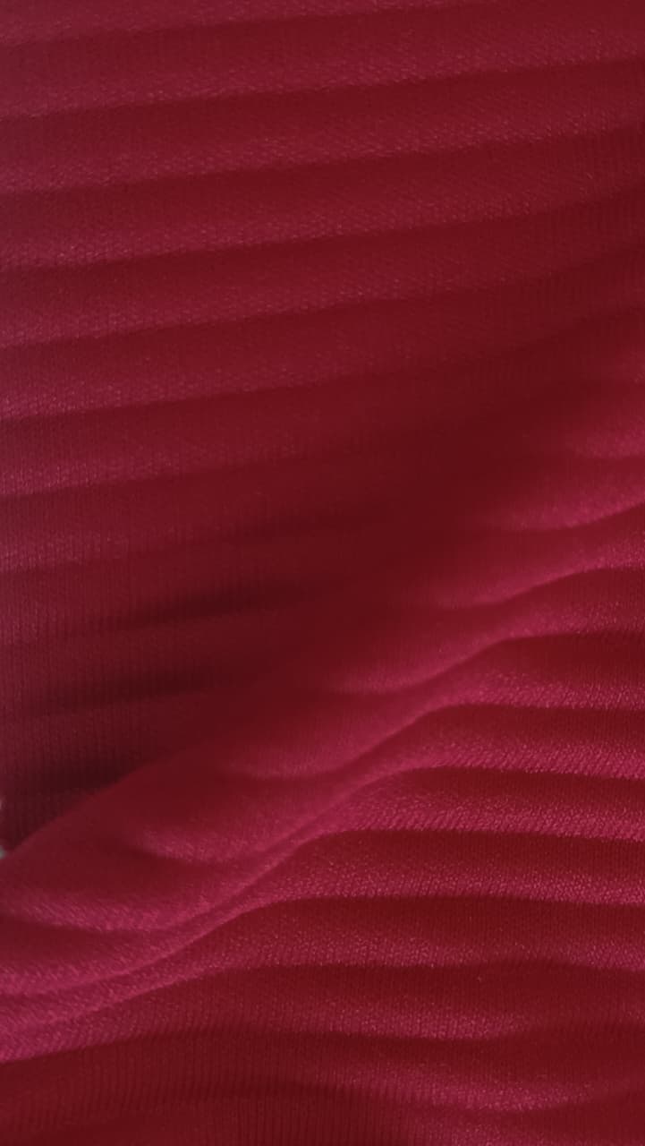 Close-up of soft, wrinkled pink cotton fabric displaying fine weave texture.