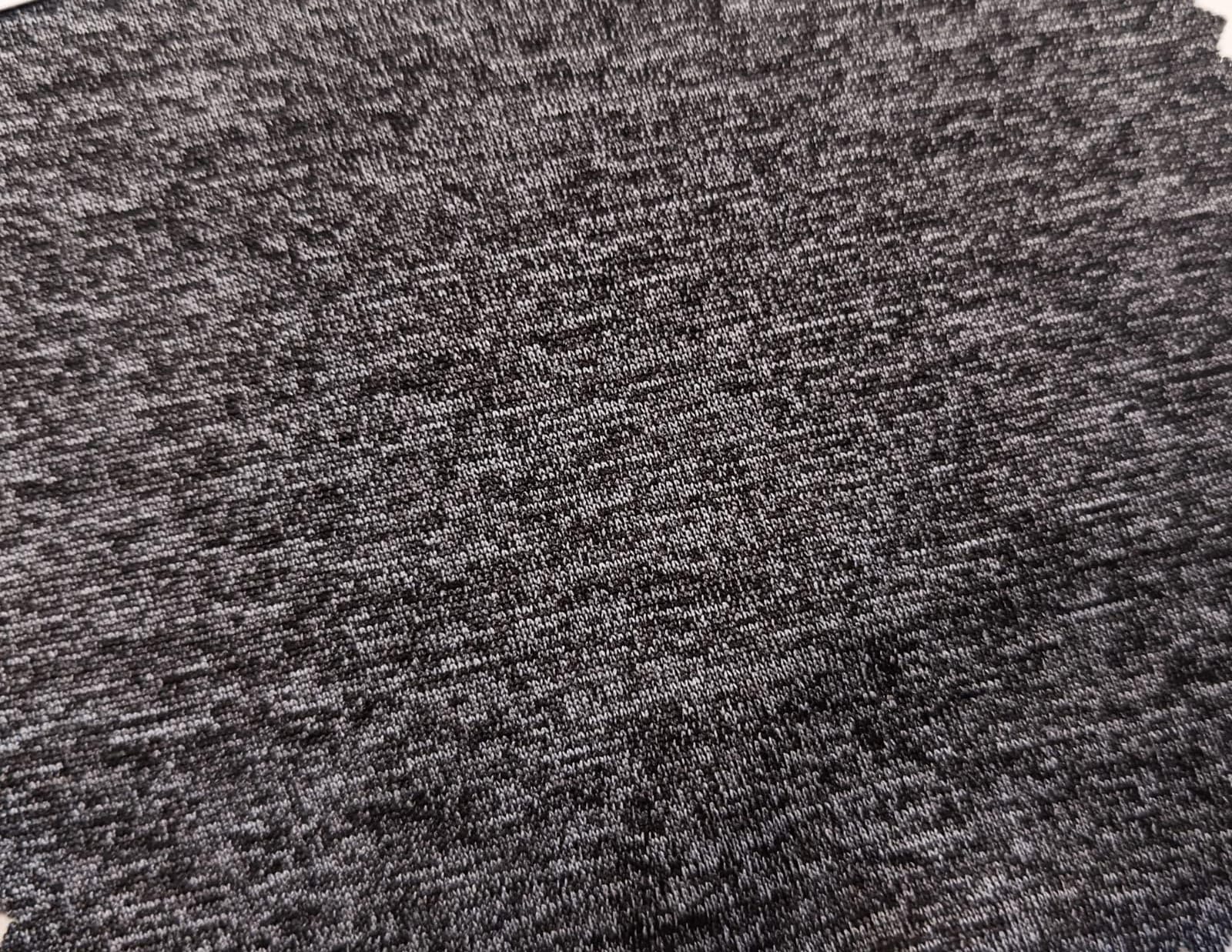 Close-up of soft, wrinkled pink cotton fabric displaying fine weave texture.