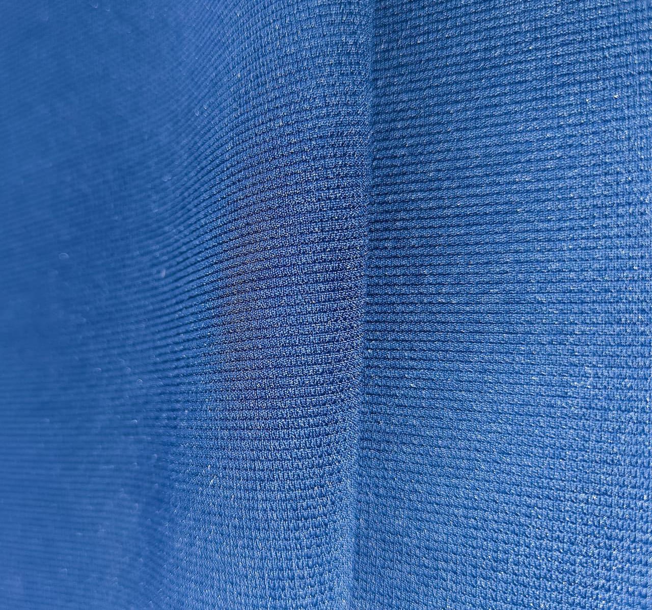 Close-up of soft, wrinkled pink cotton fabric displaying fine weave texture.