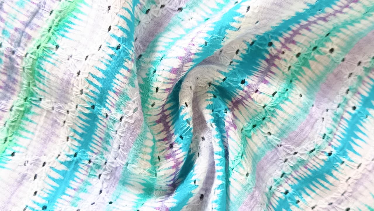 Close-up of soft, wrinkled pink cotton fabric displaying fine weave texture.