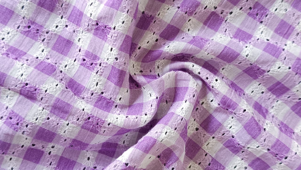 Close-up of soft, wrinkled pink cotton fabric displaying fine weave texture.