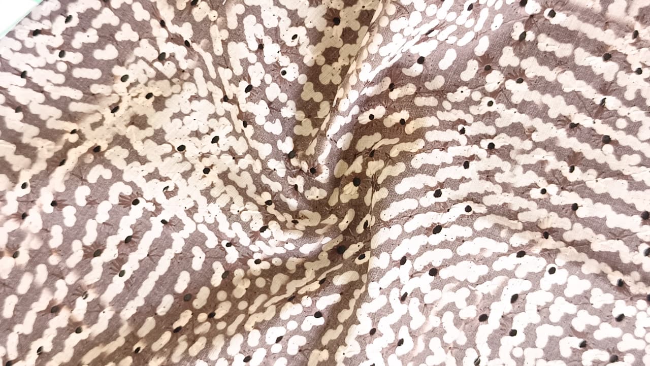 Close-up of soft, wrinkled pink cotton fabric displaying fine weave texture.