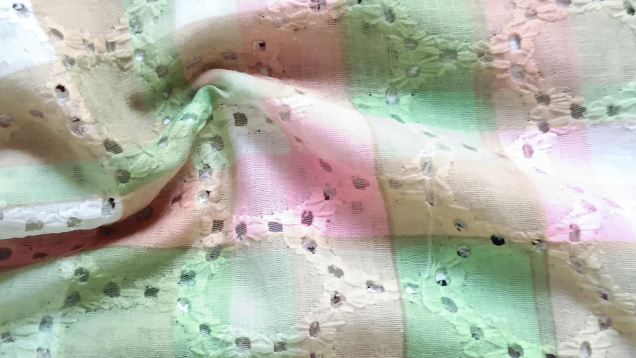 Close-up of soft, wrinkled pink cotton fabric displaying fine weave texture.