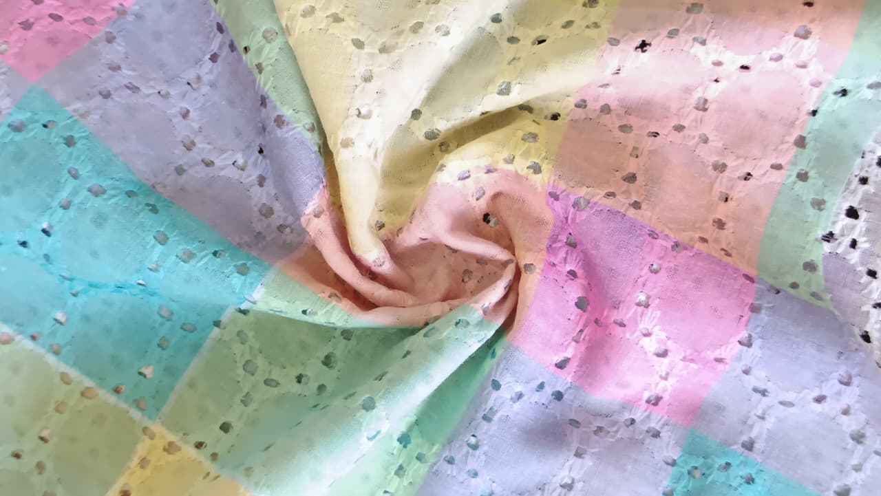 Close-up of soft, wrinkled pink cotton fabric displaying fine weave texture.