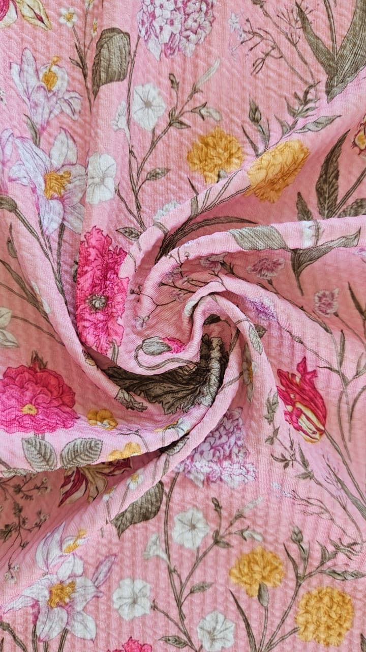 Close-up of soft, wrinkled pink cotton fabric displaying fine weave texture.