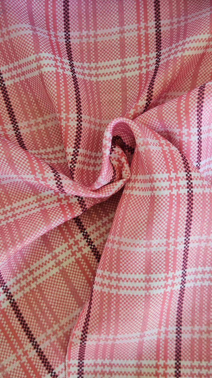 Close-up of soft, wrinkled pink cotton fabric displaying fine weave texture.