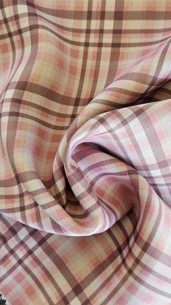 Close-up of soft, wrinkled pink cotton fabric displaying fine weave texture.