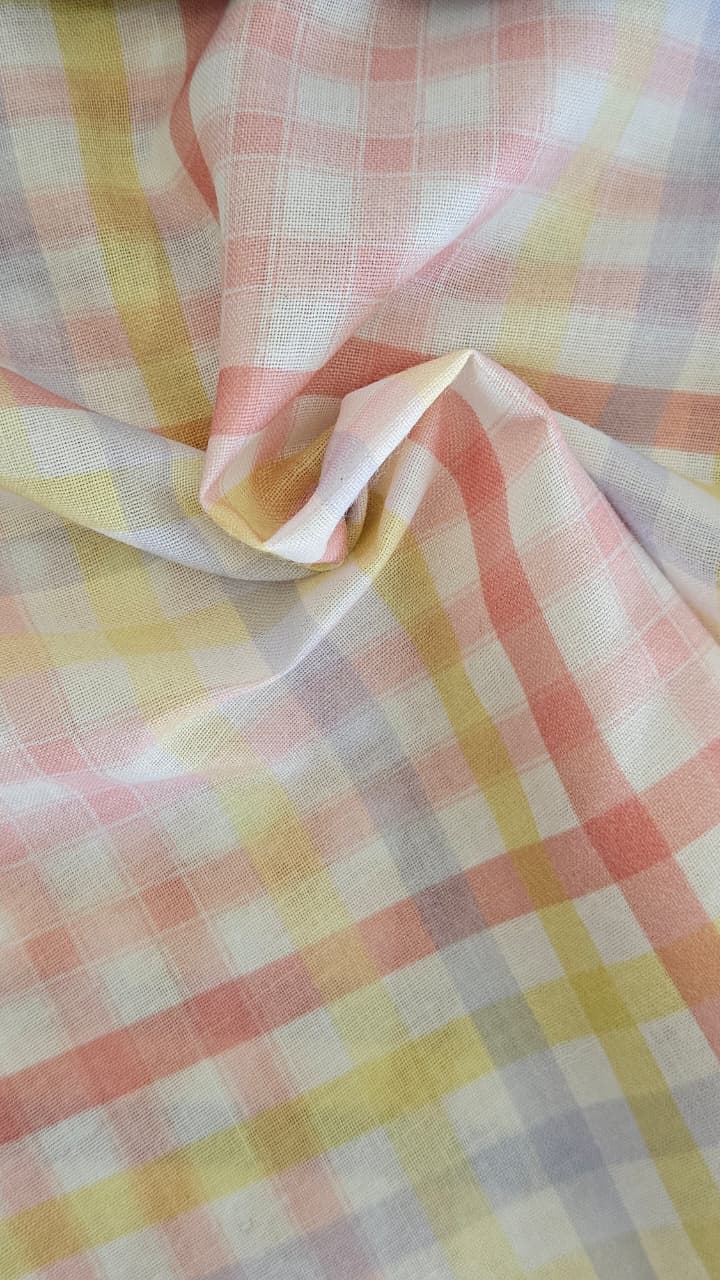 Close-up of soft, wrinkled pink cotton fabric displaying fine weave texture.