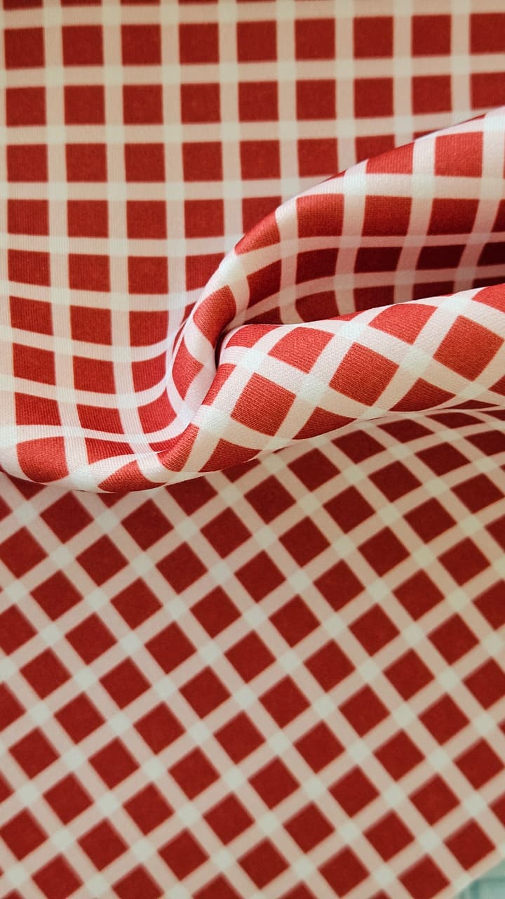 Close-up of soft, wrinkled pink cotton fabric displaying fine weave texture.