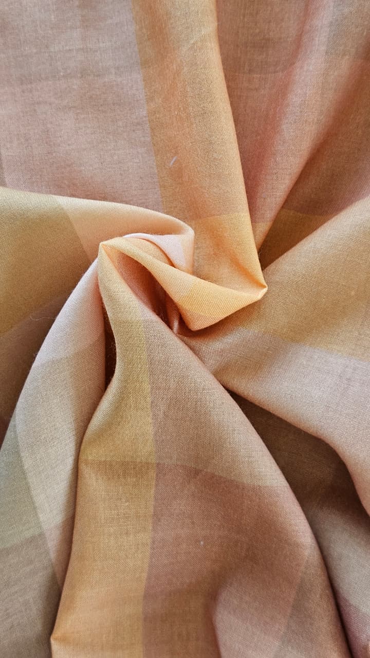 Close-up of soft, wrinkled pink cotton fabric displaying fine weave texture.