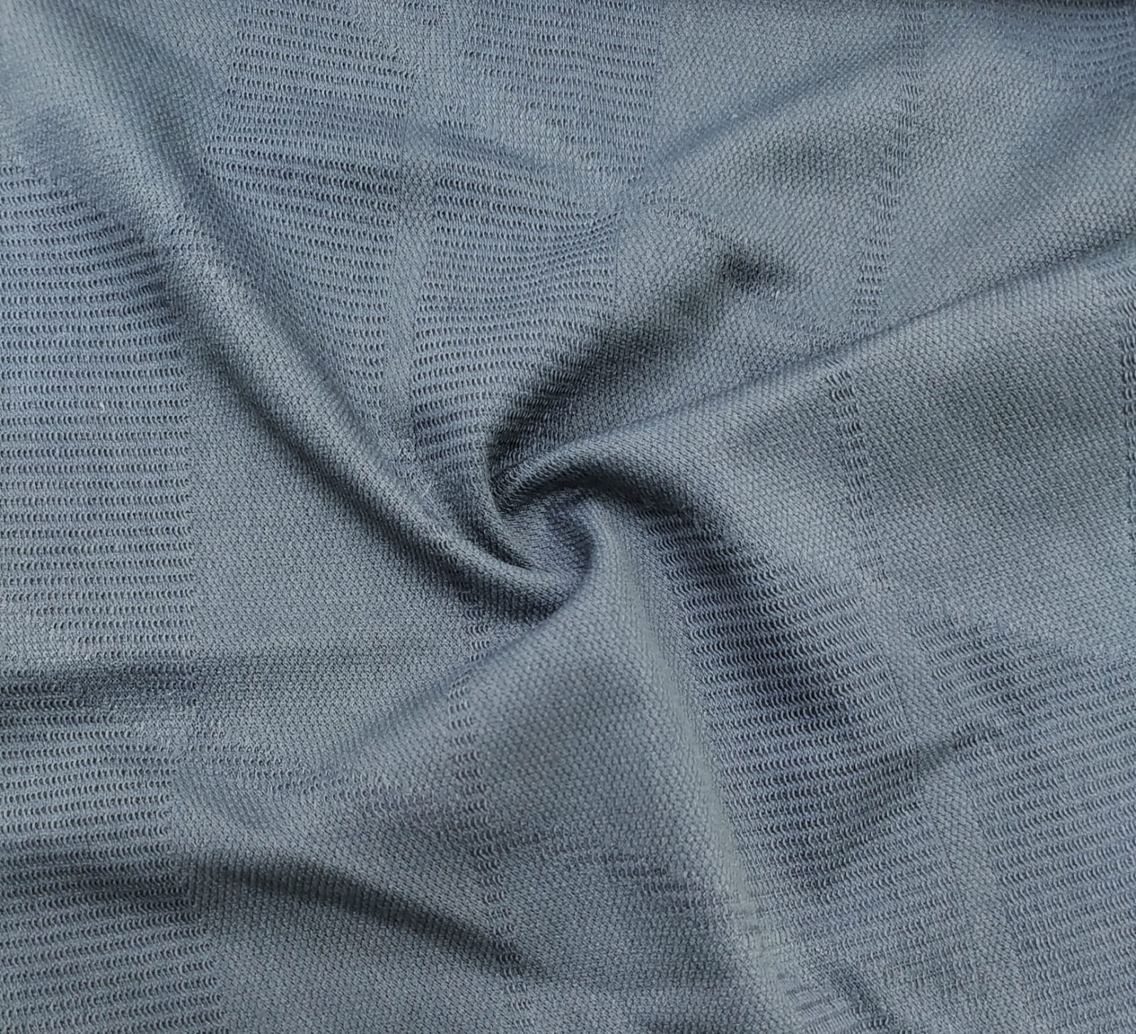 Close-up of soft, wrinkled pink cotton fabric displaying fine weave texture.