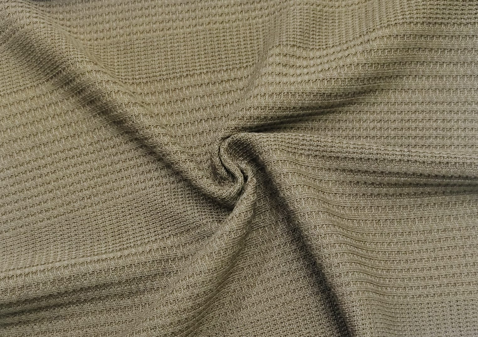 Close-up of soft, wrinkled pink cotton fabric displaying fine weave texture.