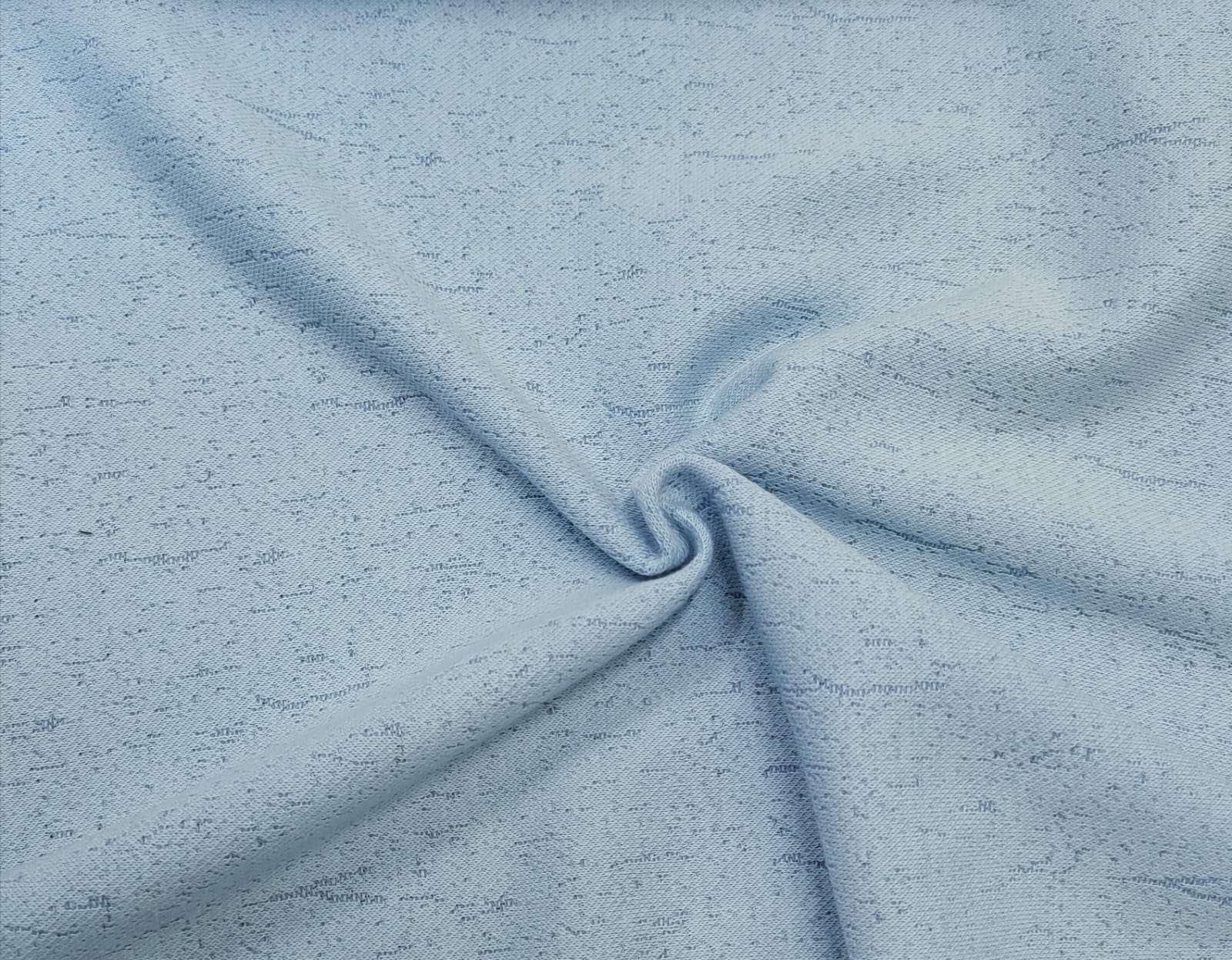 Close-up of soft, wrinkled pink cotton fabric displaying fine weave texture.