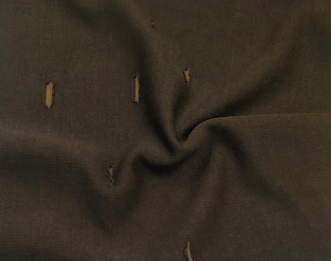 Close-up of soft, wrinkled pink cotton fabric displaying fine weave texture.