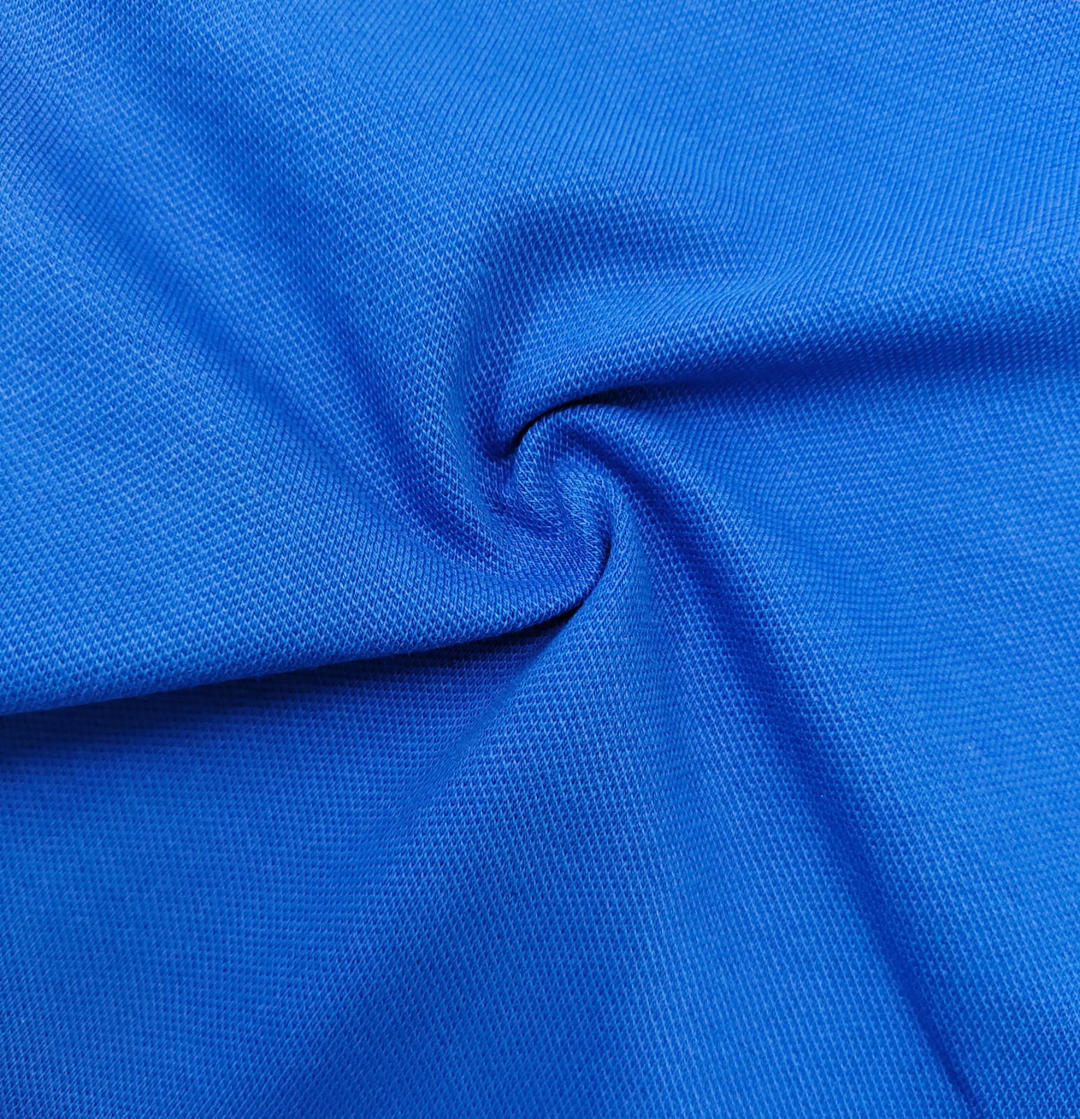 Close-up of soft, wrinkled pink cotton fabric displaying fine weave texture.