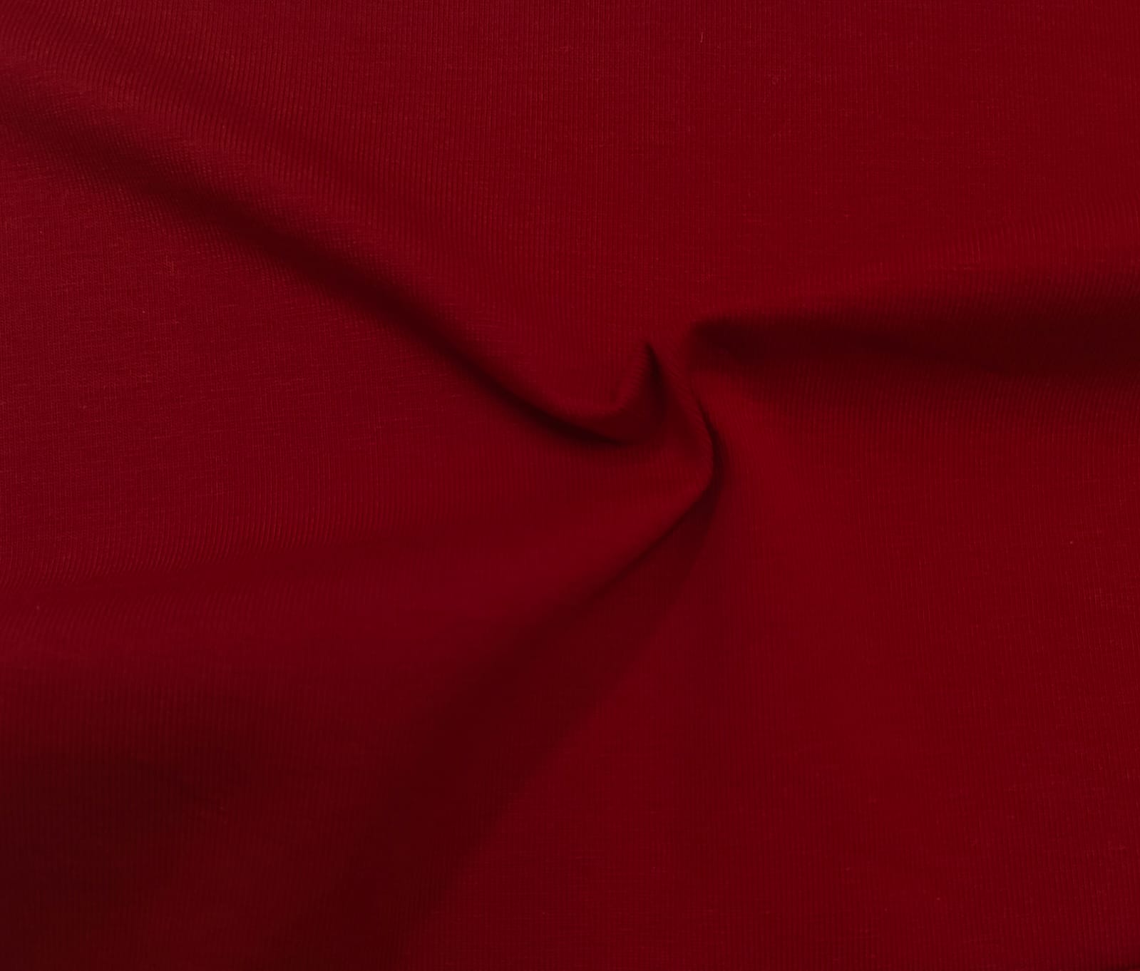 Close-up of soft, wrinkled pink cotton fabric displaying fine weave texture.