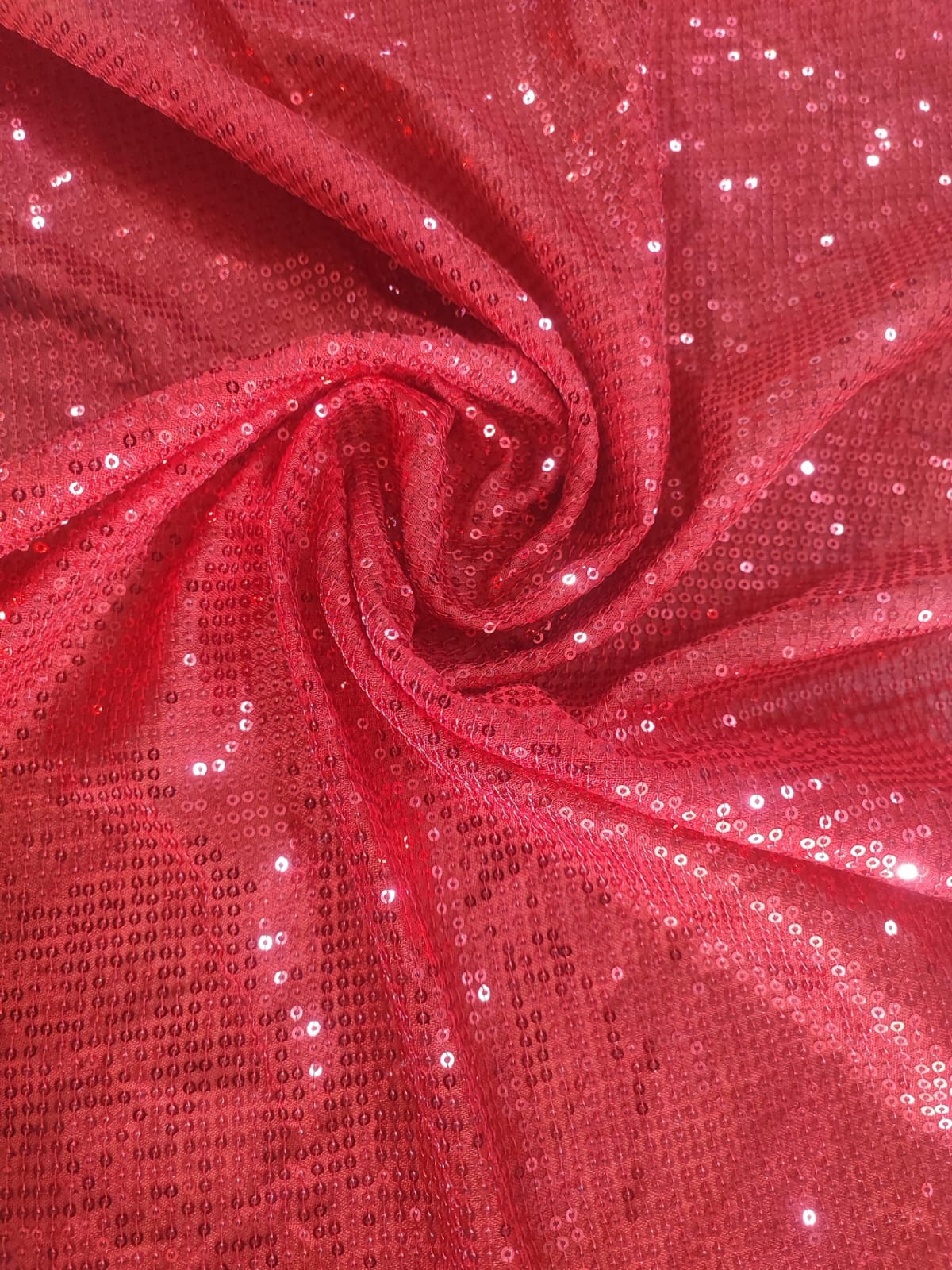 Close-up of soft, wrinkled pink cotton fabric displaying fine weave texture.