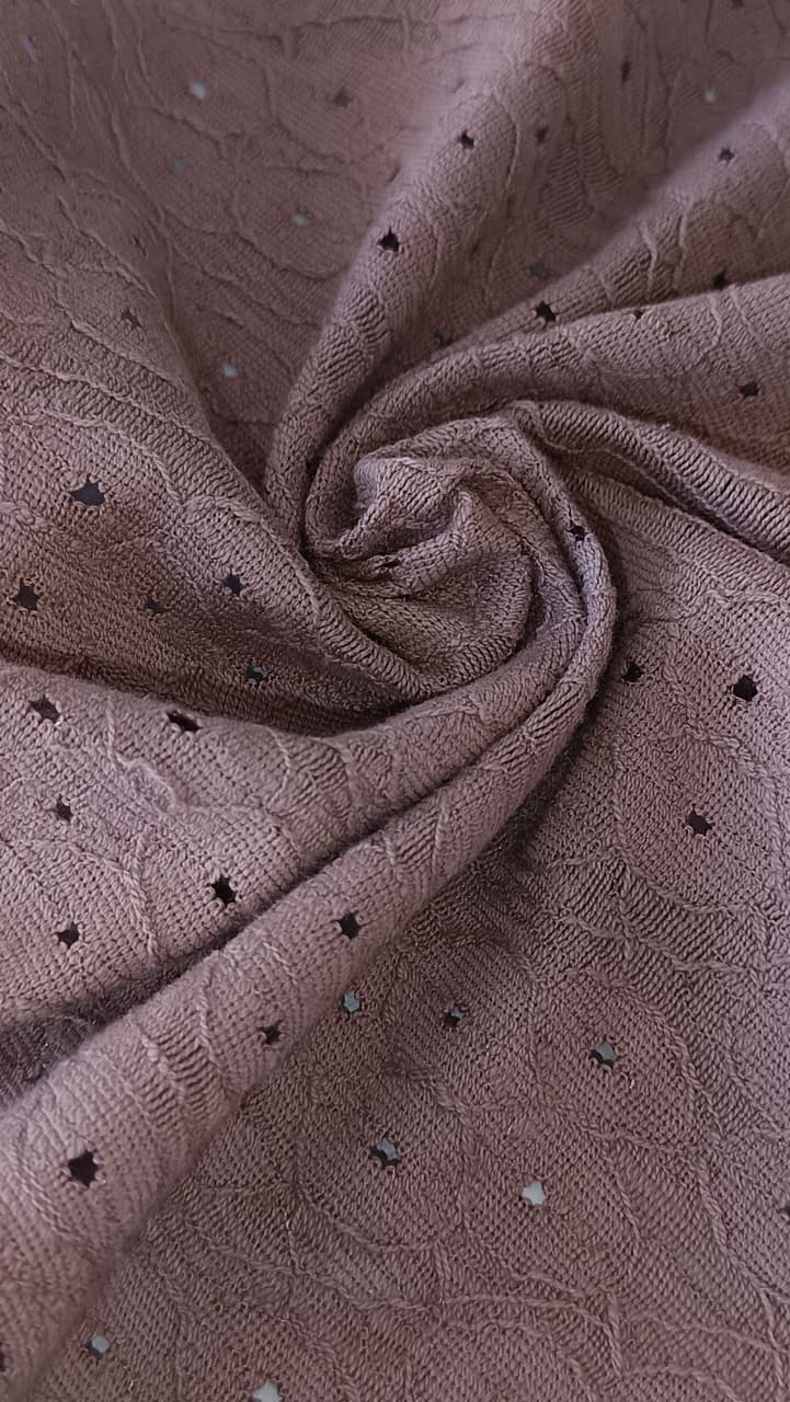 Close-up of soft, wrinkled pink cotton fabric displaying fine weave texture.