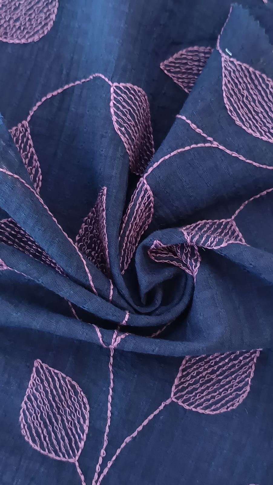 Close-up of soft, wrinkled pink cotton fabric displaying fine weave texture.
