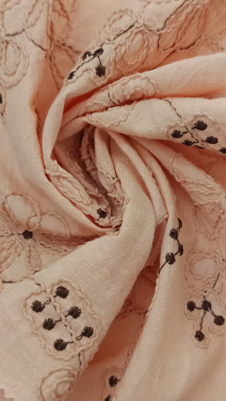 Close-up of soft, wrinkled pink cotton fabric displaying fine weave texture.
