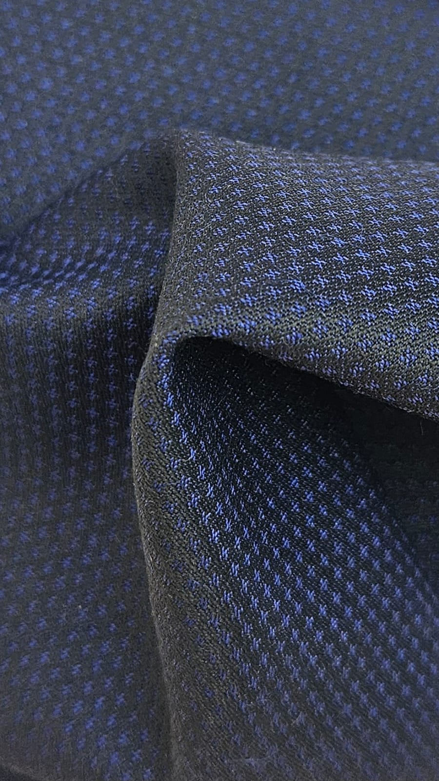 Close-up of soft, wrinkled pink cotton fabric displaying fine weave texture.