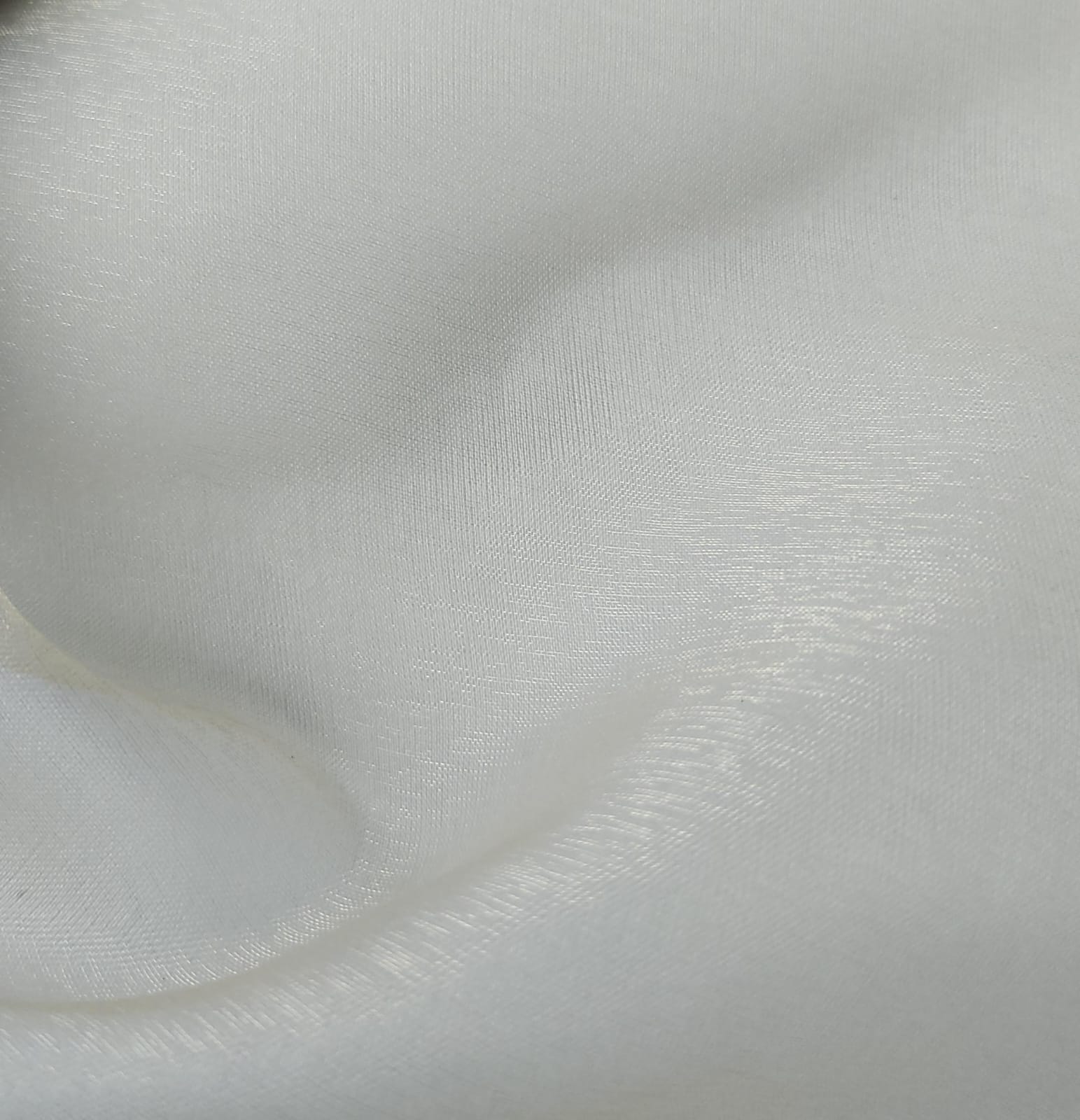 Close-up of soft, wrinkled pink cotton fabric displaying fine weave texture.