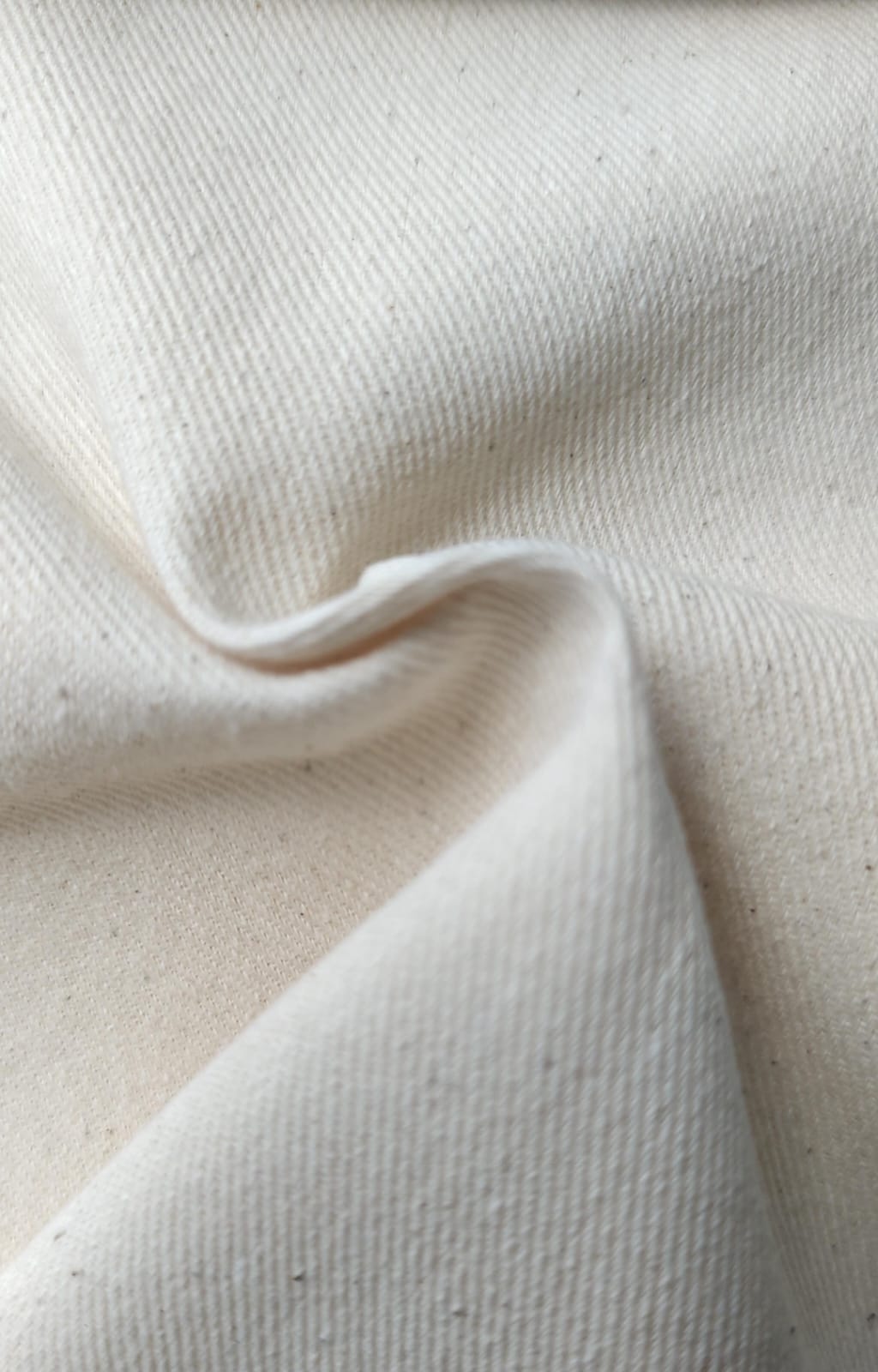 Close-up of soft, wrinkled pink cotton fabric displaying fine weave texture.