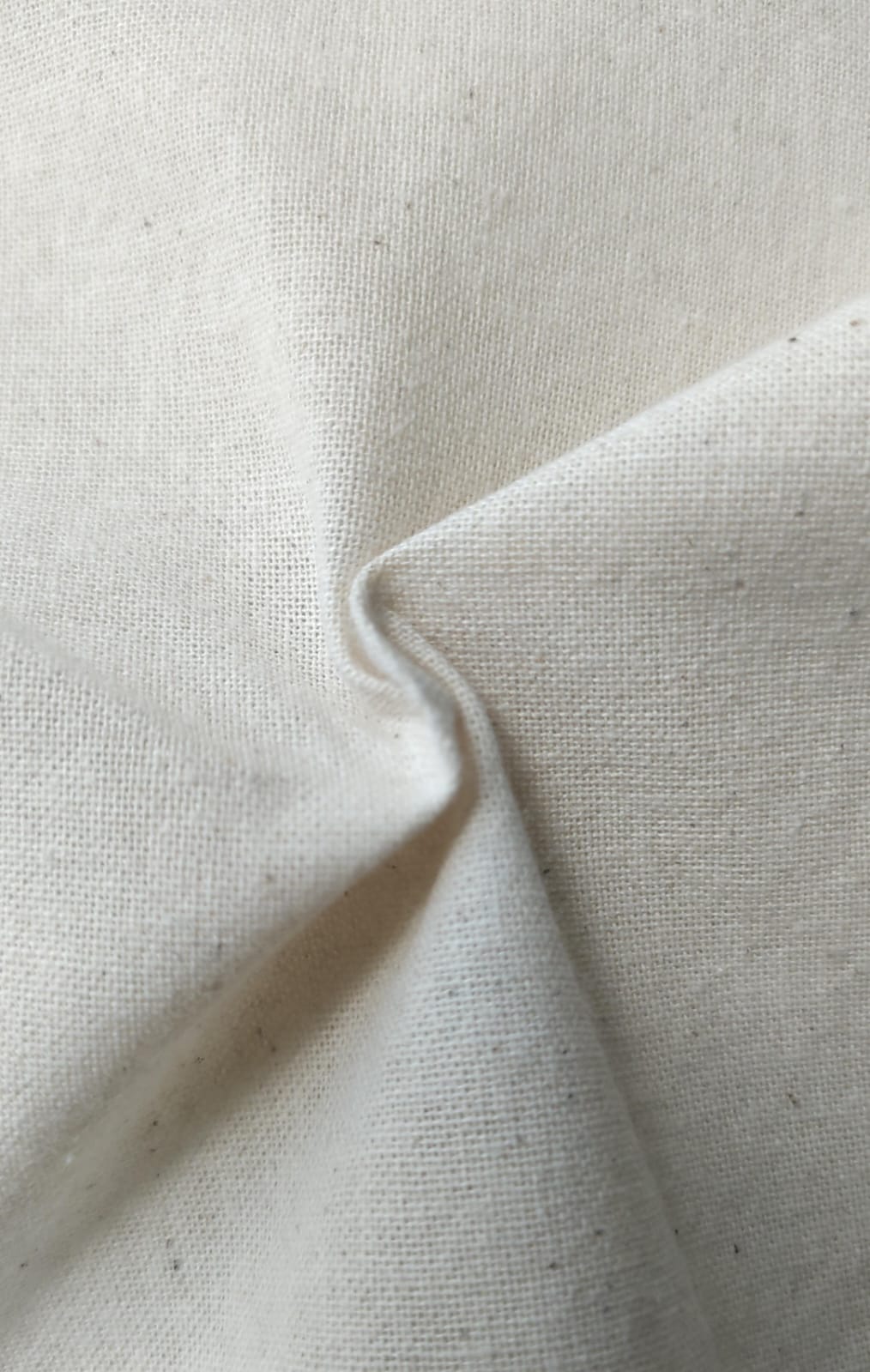 Close-up of soft, wrinkled pink cotton fabric displaying fine weave texture.