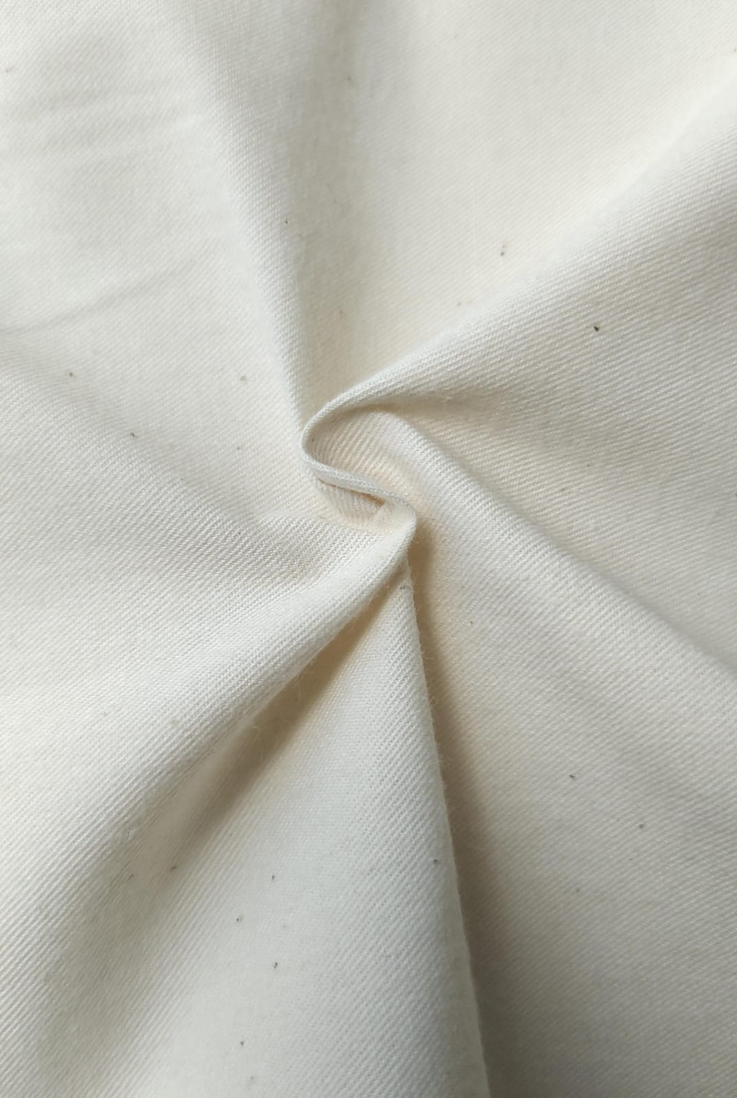 Close-up of soft, wrinkled pink cotton fabric displaying fine weave texture.