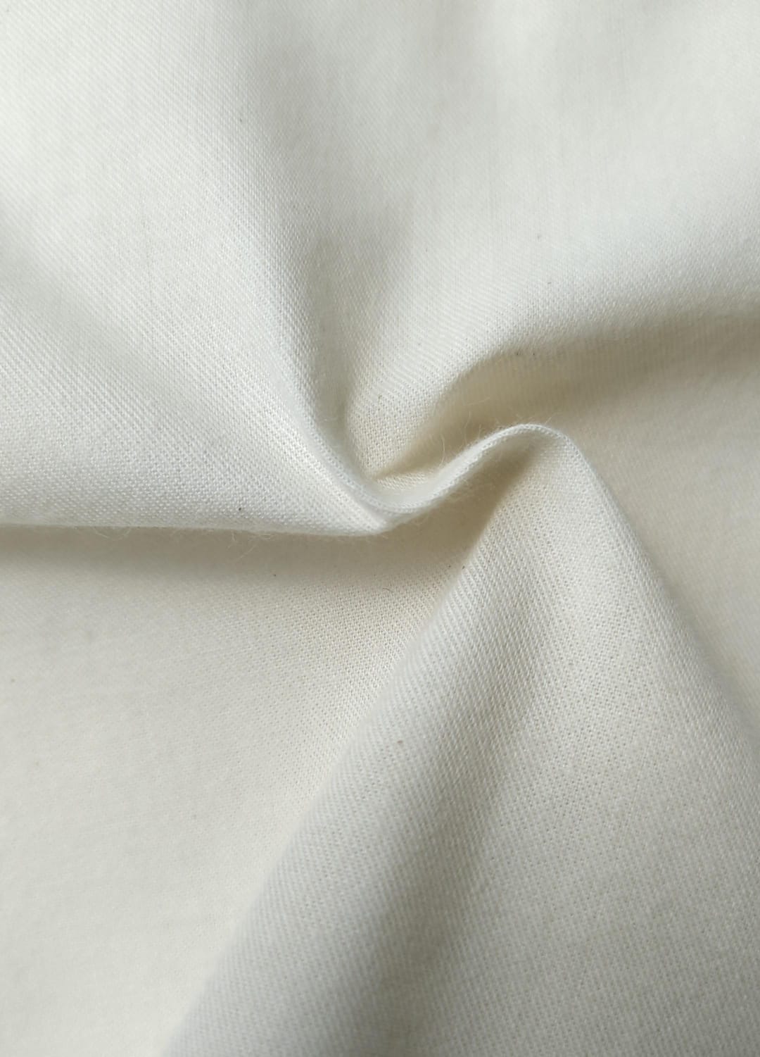 Close-up of soft, wrinkled pink cotton fabric displaying fine weave texture.